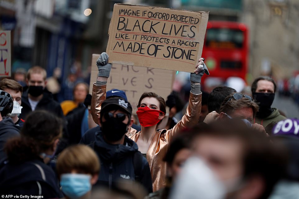 A protester holds up a sign reading 