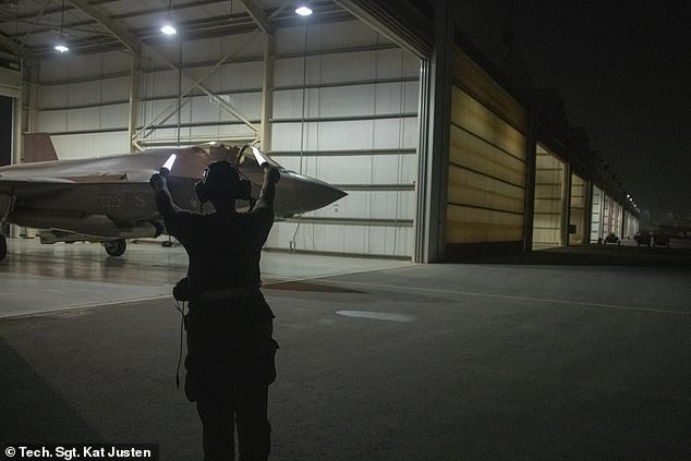 A member of the Air Force ground crew directs Thompson