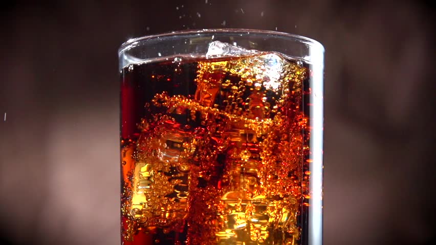 Cola with ice. Pouring Cola with Ice and bubbles in glass. Soda ...