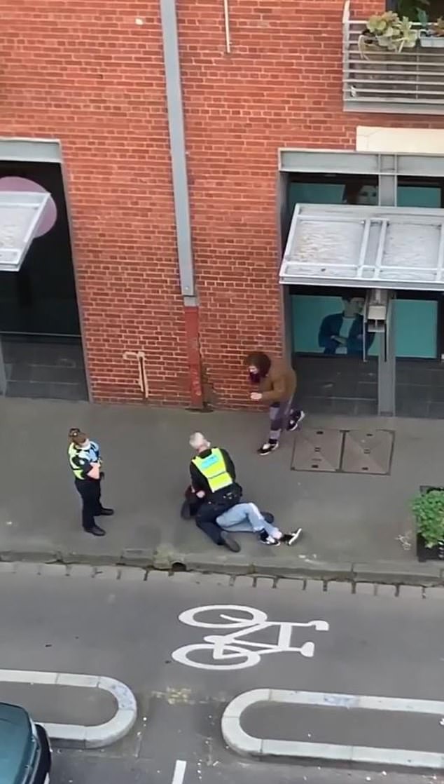 The man in the purple scarf then yells for the officer to get off her, saying she has an excuse for not wearing a mask. 
