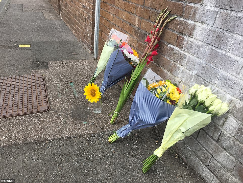 Residents gathered this morning to lay flowers, above, in tribute to the child. An investigation is underway into the incident which neighbours have called a 