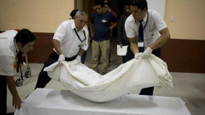 Tres personas transportan un cadáver, en una imagen de archivo.