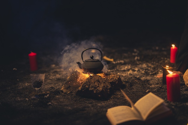 Arreglo de brujería con tetera en el medio | Foto Gratis