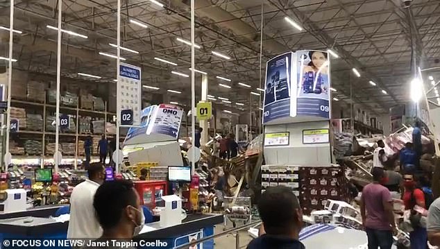 People rush towards the piles of goods to help people trapped underneath