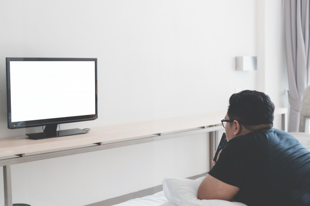 Hombre viendo la televisión en casa | Foto Premium