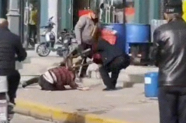 A man appears to beat a woman in the streets of Shuozhou in China.