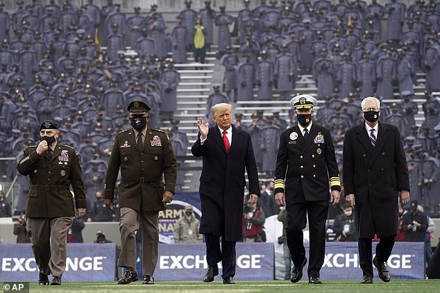 Trump is flanked by Army and Navy officials as he walks onto the field. By tradition, the president visits both locker rooms and sits on each sideline for one half of the game to avoid any appearance of partiality