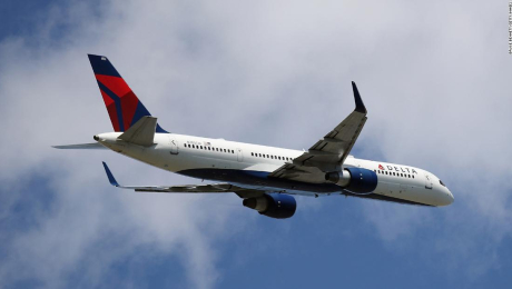 2 pasajeros con un perro abren puerta de avión en movimiento de Delta