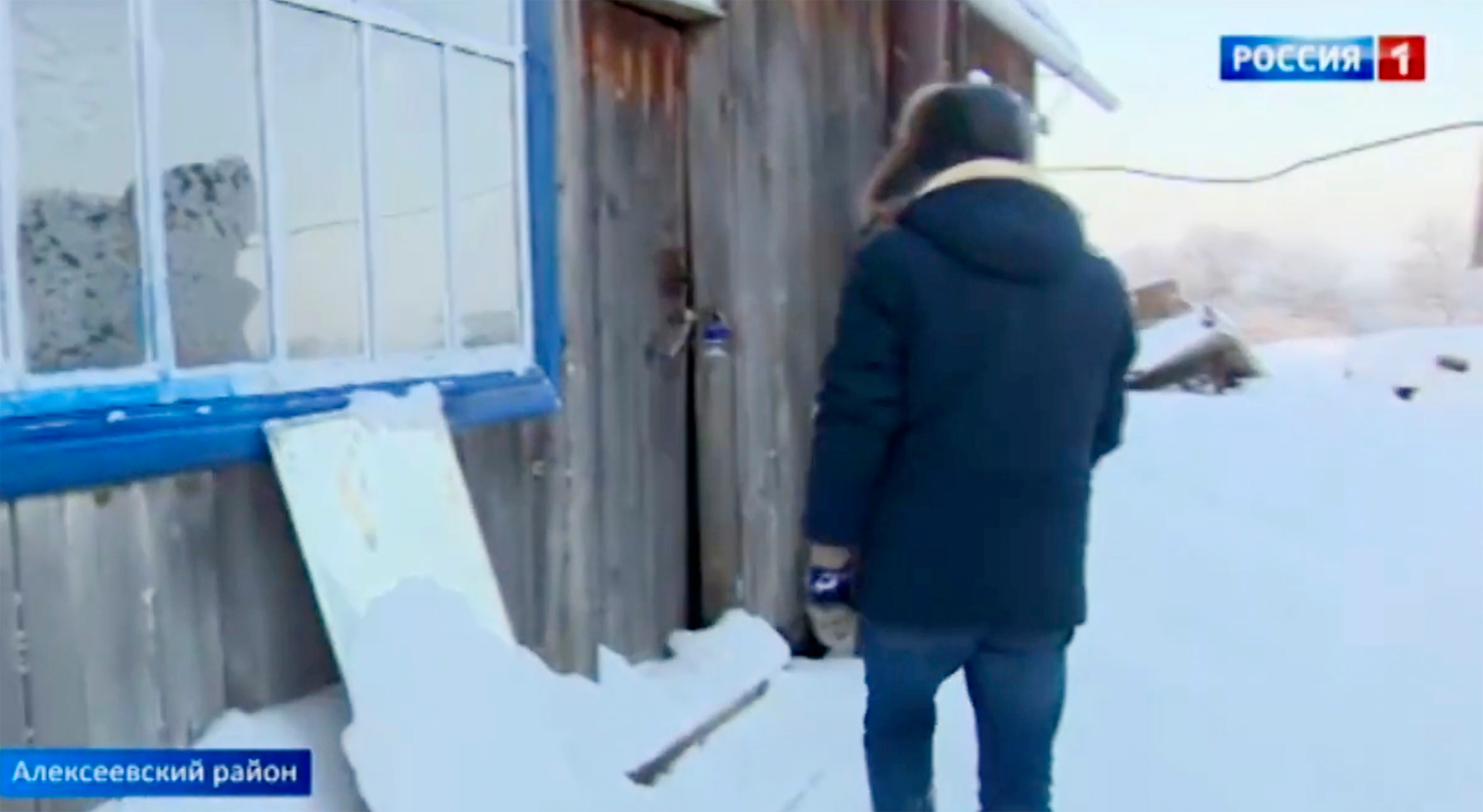 Journalist stands in front of the abandoned house where the boy was found