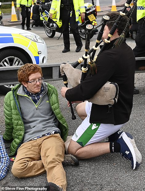 A motorist plays the bagpipes in Kent today
